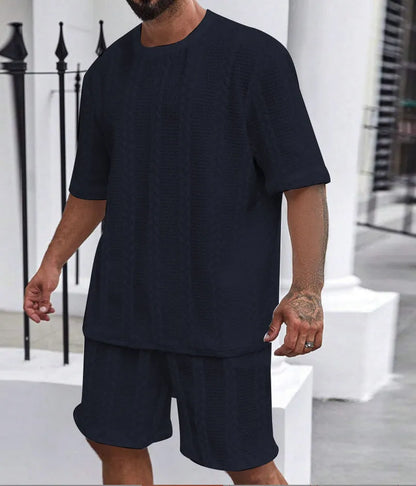 Knitted short-sleeve pullover and matching shorts set in light grey, laid flat.