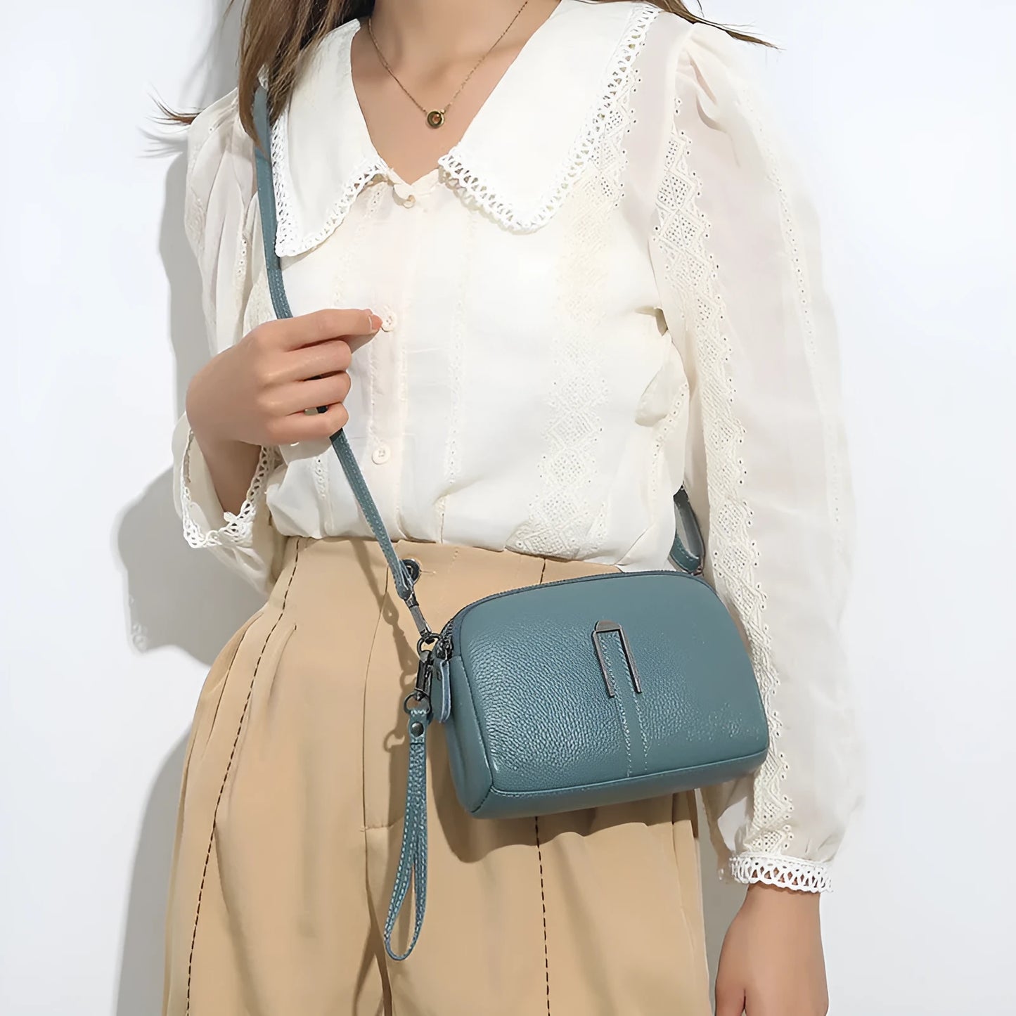 Women's genuine leather square shoulder bag in black, shown from front, displaying structured horizontal shape.