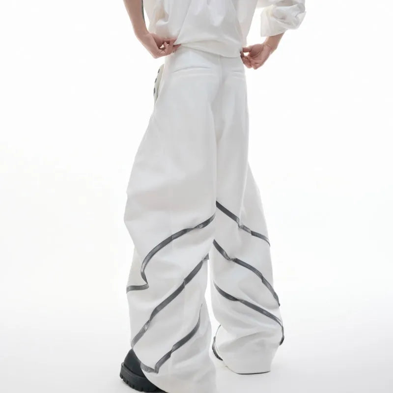 Men's trousers with three-dimensional cutting and metal striped rivet pleats in black or white, showing tailored fit and detail