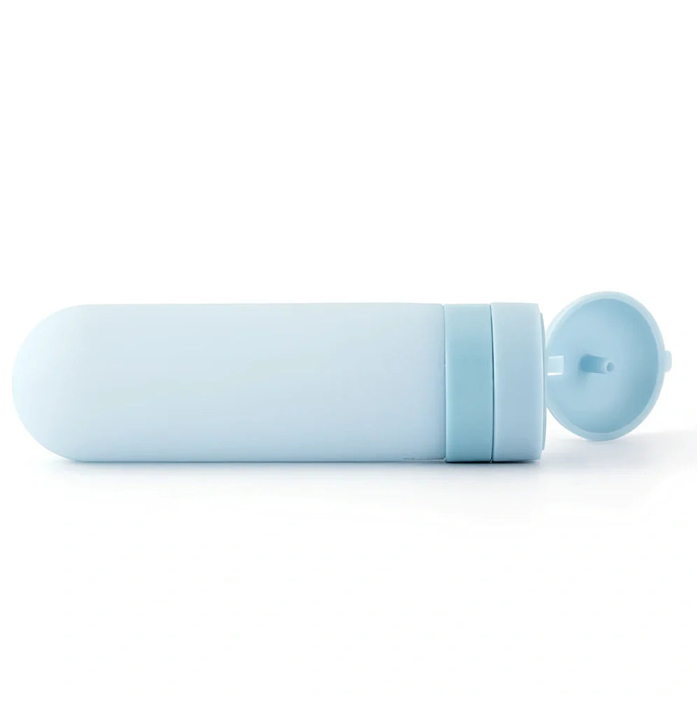 Set of three silicone travel bottles in light grey, pink, and blue colours with screw caps