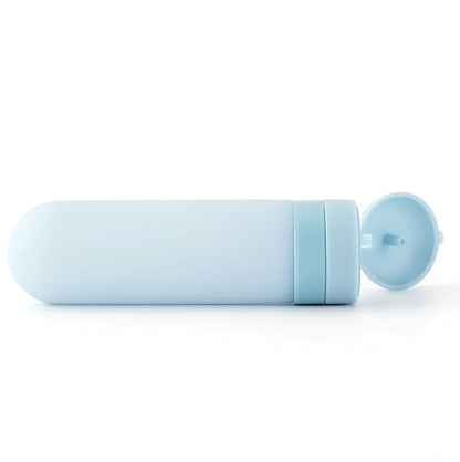Set of three silicone travel bottles in light grey, pink, and blue colours with screw caps