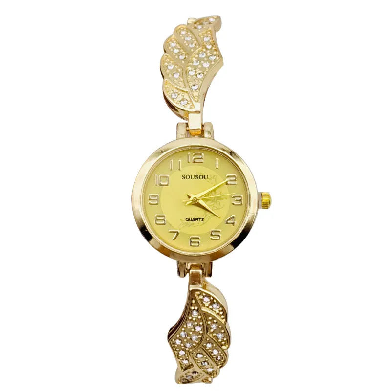 Round stainless steel women's watch on wrist showing gold surface colour and vachette clasp buckle.