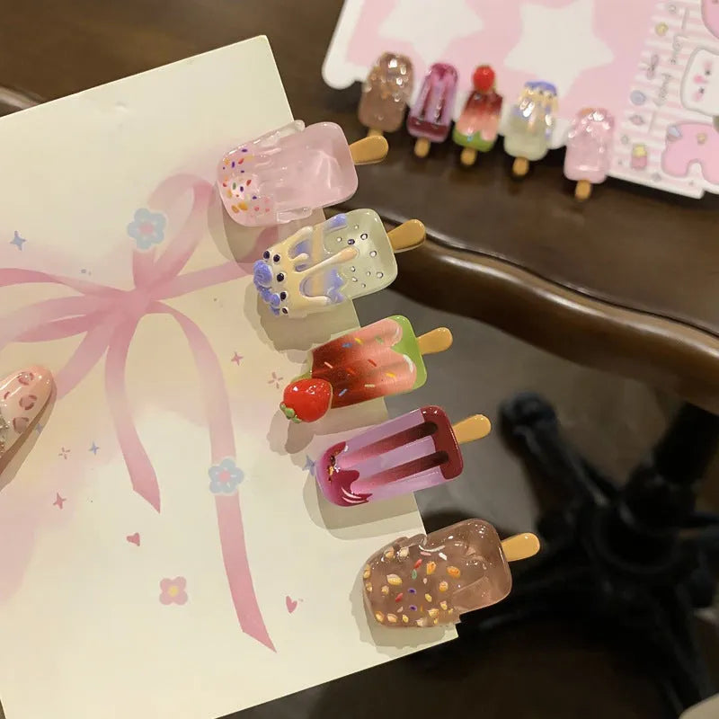 A resin hair barrette with a cartoon ice cream charm on a side-clip, shown in a pink colour variant.