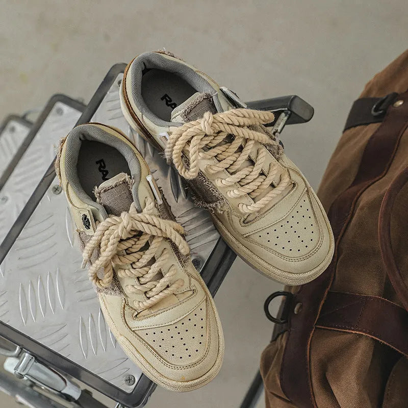 Beige low-top vintage-style skate shoes on a white background, showing round toe and lace-up front.