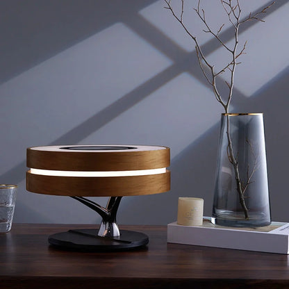 Round Bluetooth speaker with LED tree lighting and wireless charging surface in maple brown finish