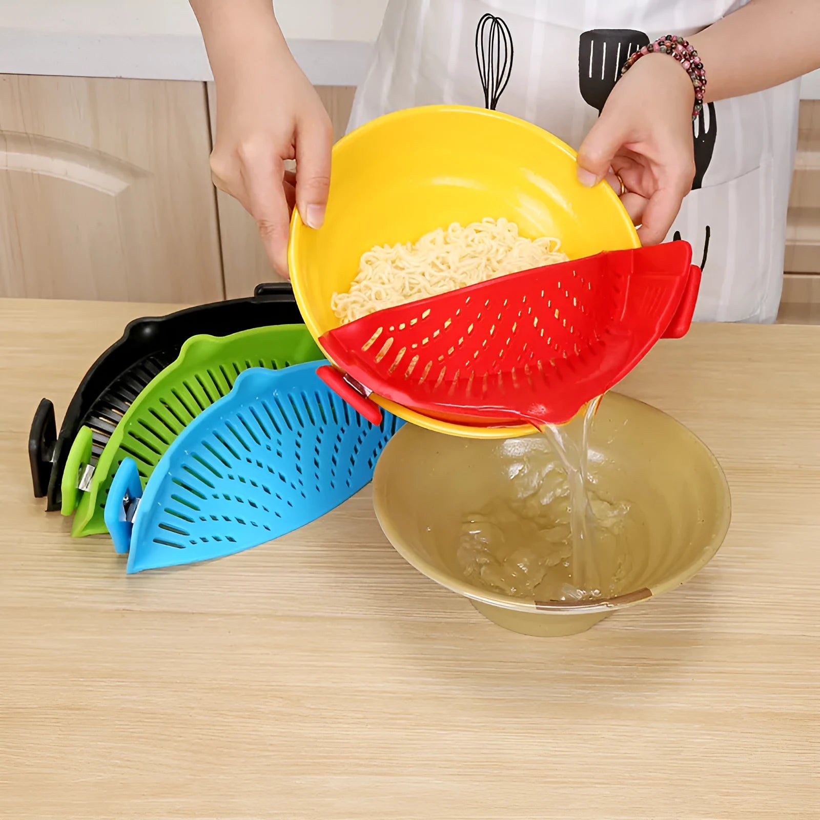 Silicone clip-on kitchen strainer with stainless steel frame attached to pot rim