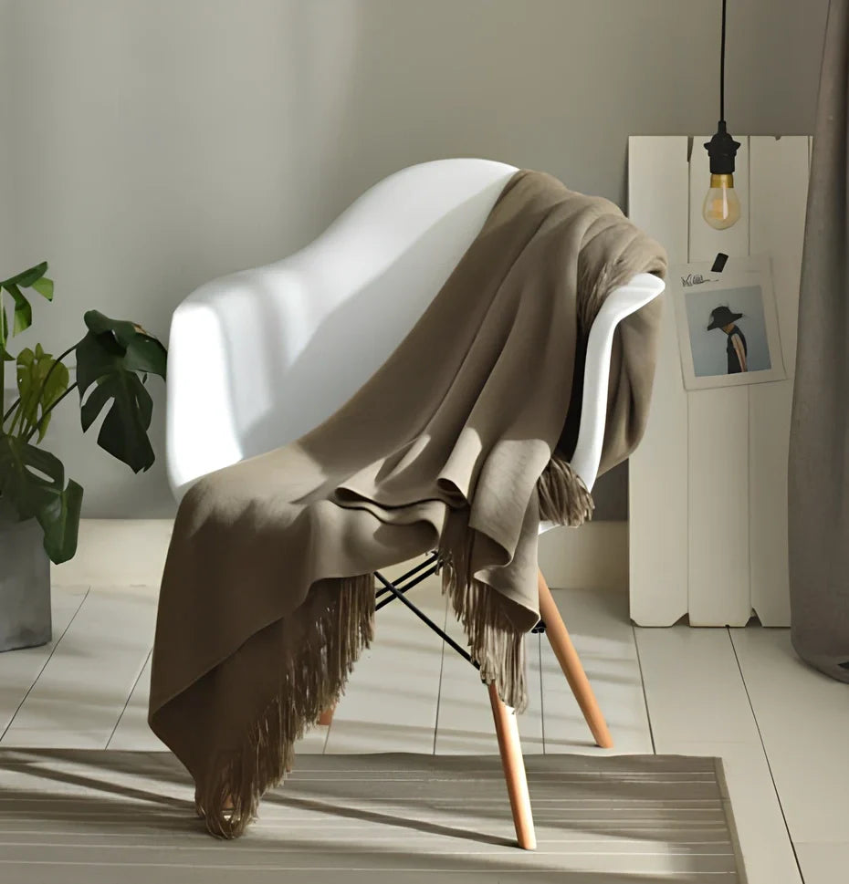 130x150cm knitted acrylic blanket with 10cm fringe detailing in beige colour draped over sofa