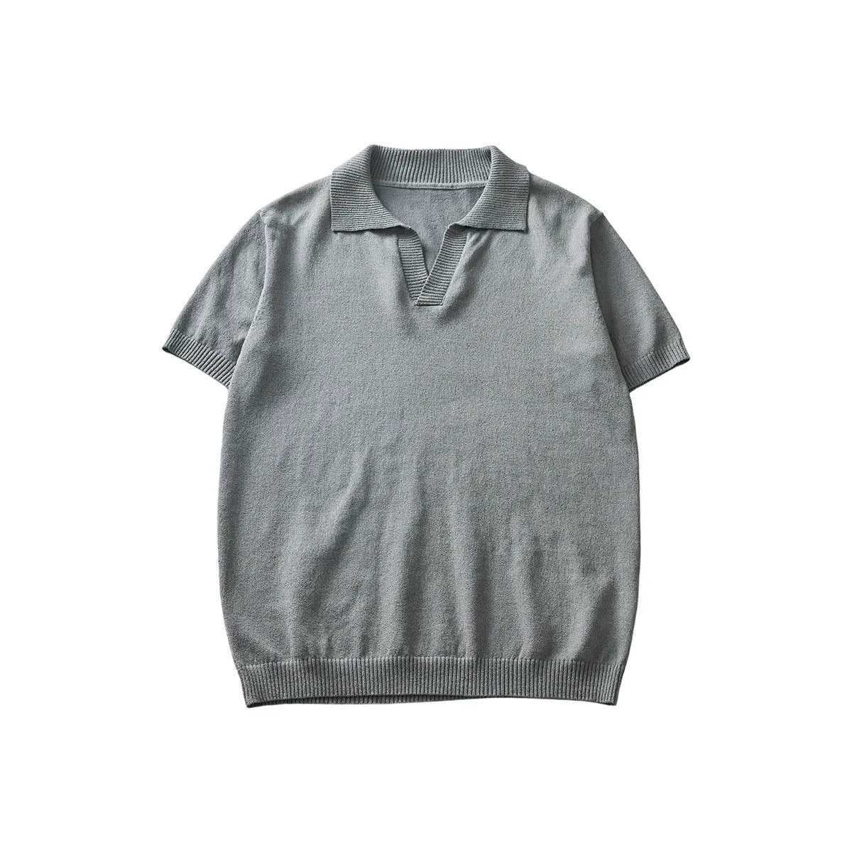 A man's solid-colour knitted polo t-shirt with short sleeves and a collar, shown in navy blue.
