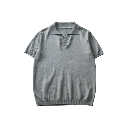 A man's solid-colour knitted polo t-shirt with short sleeves and a collar, shown in navy blue.