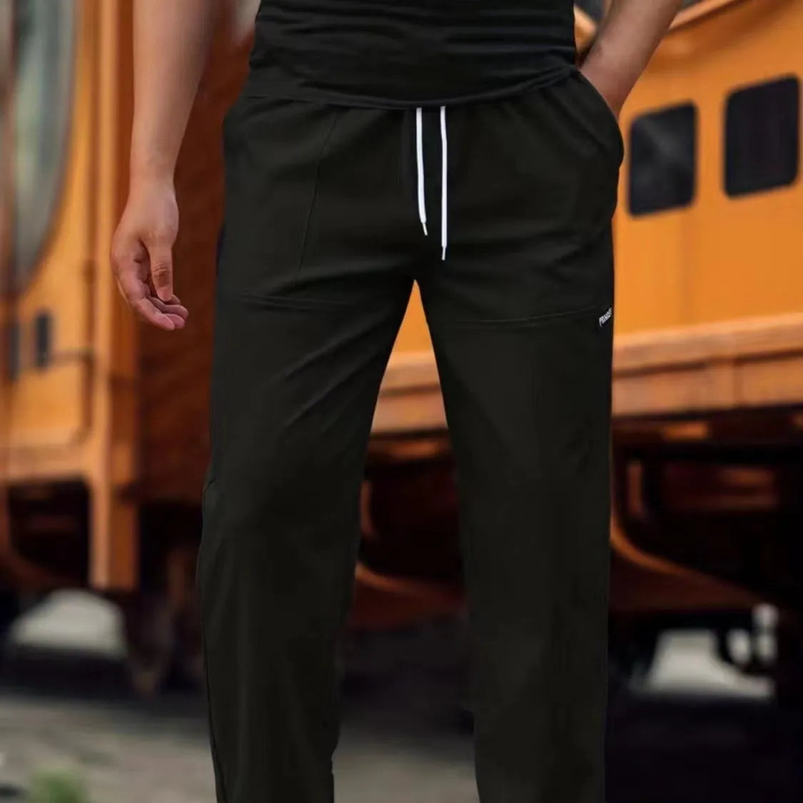 Men's polyester trousers for spring and autumn in light grey, shown in a casual setting