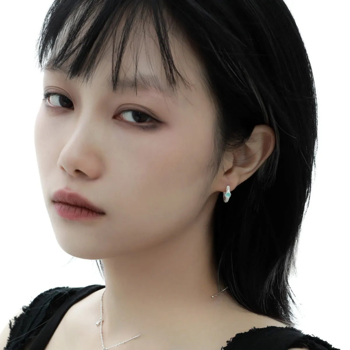 A pair of geometric round ear clips made from 925 silver with a burnt silver electroplated finish.