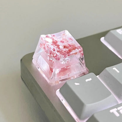 A transparent resin keycap with a starry sky design inside, shown in a green colour variant.