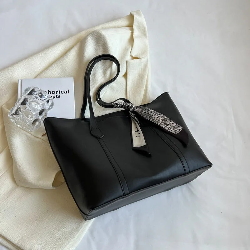 Soft large-capacity bucket tote bag with shoulder strap and zip pocket, shown in a neutral colour.