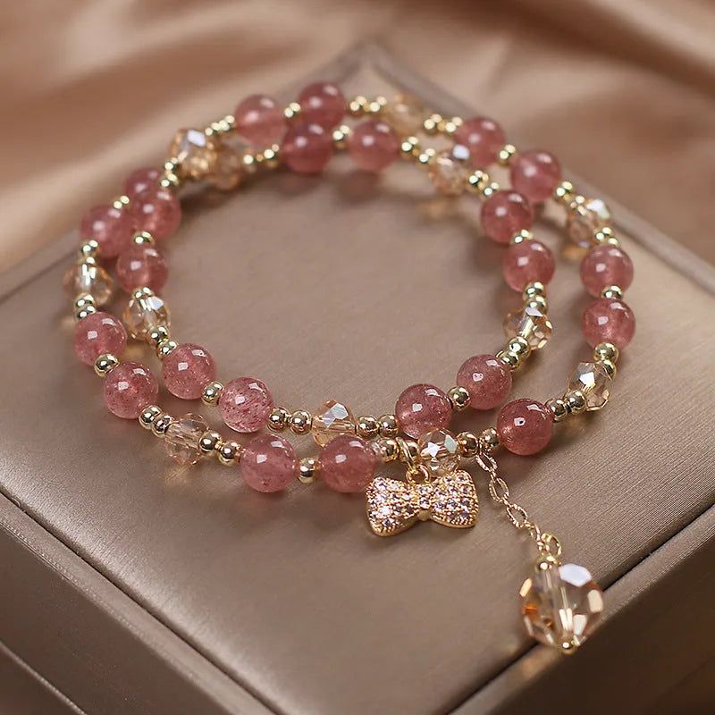 Double-layer strawberry quartz crystal bracelet with lucky cat charm and red cat's eye flowers design.