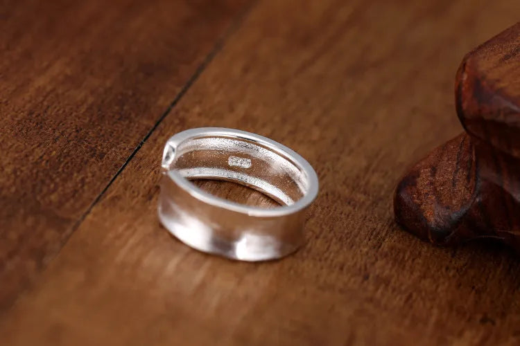 Geometric open sterling silver ring with frosted finish and adjustable gap.