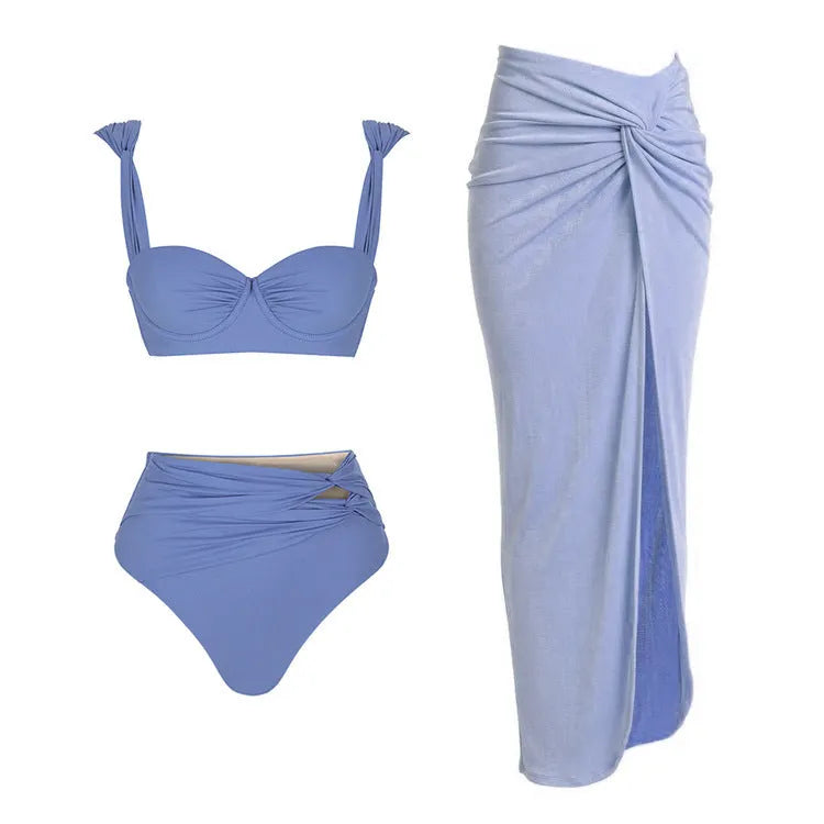 A woman's solid-colour one-piece swimsuit with a gold button detail and an attached matching skirt.