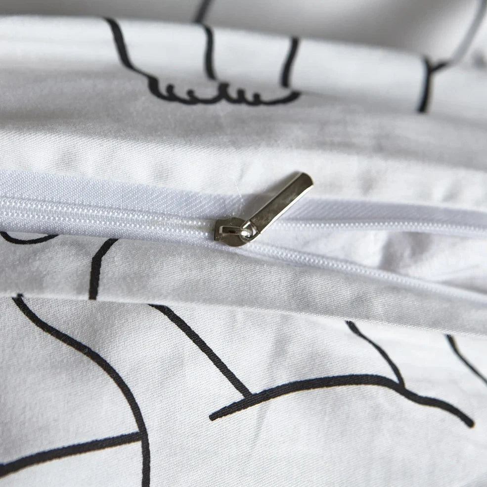 White cotton bedding set with active printed pattern, showing duvet cover, fitted sheet and pillowcases