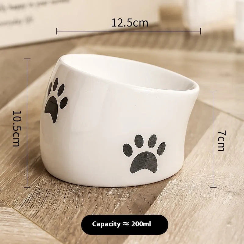 Ceramic cat bowl with high foot and cat's paw base in an oblique mouth design.