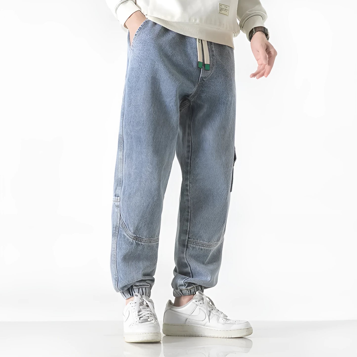 Men's loose-fit tapered cotton trousers in black showing mid-waist design and tapered leg opening