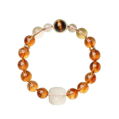 Close-up of a women's carved citrine bracelet with geometric patterns on 10mm crystal beads.