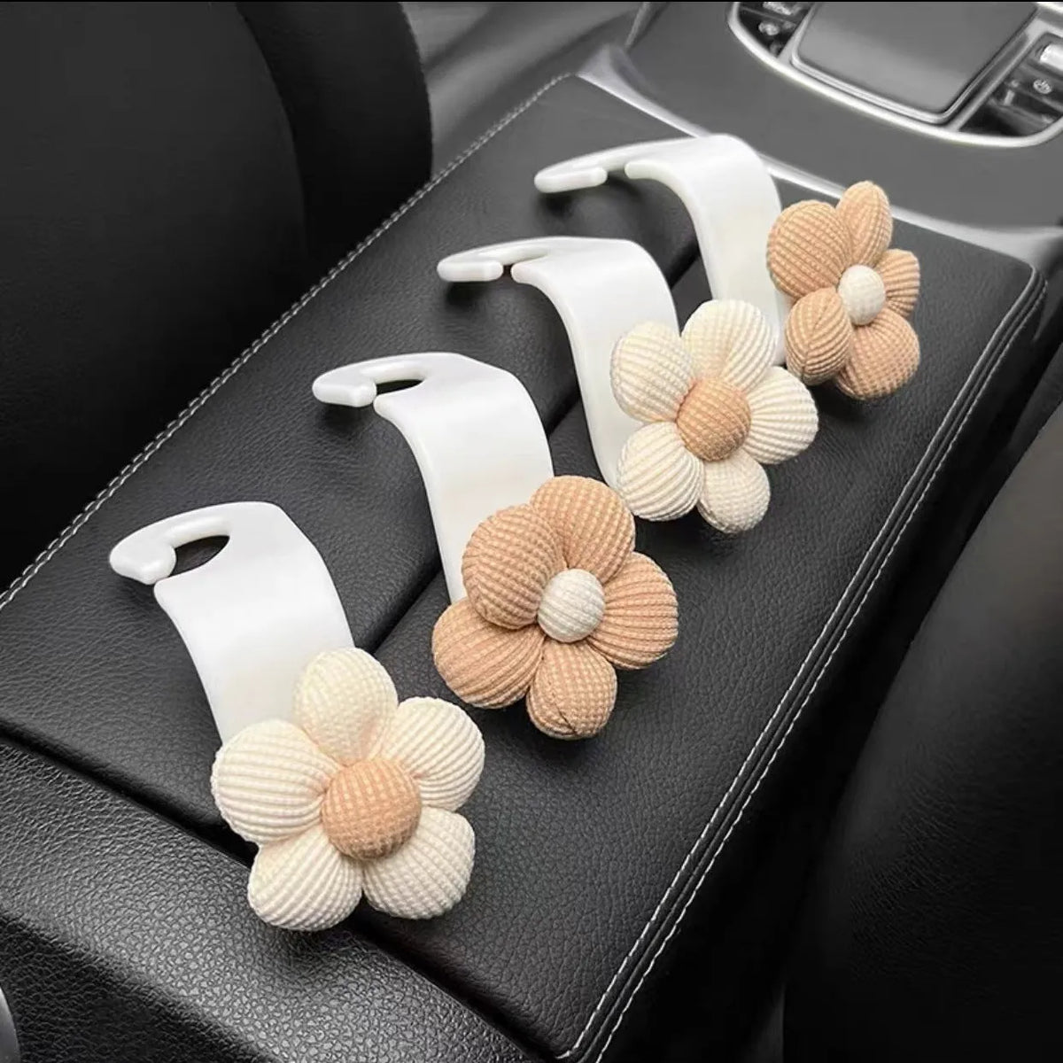 Khaki coloured plastic car seat hook with floral pattern for storage, shown at 11 by 5.5 cm.