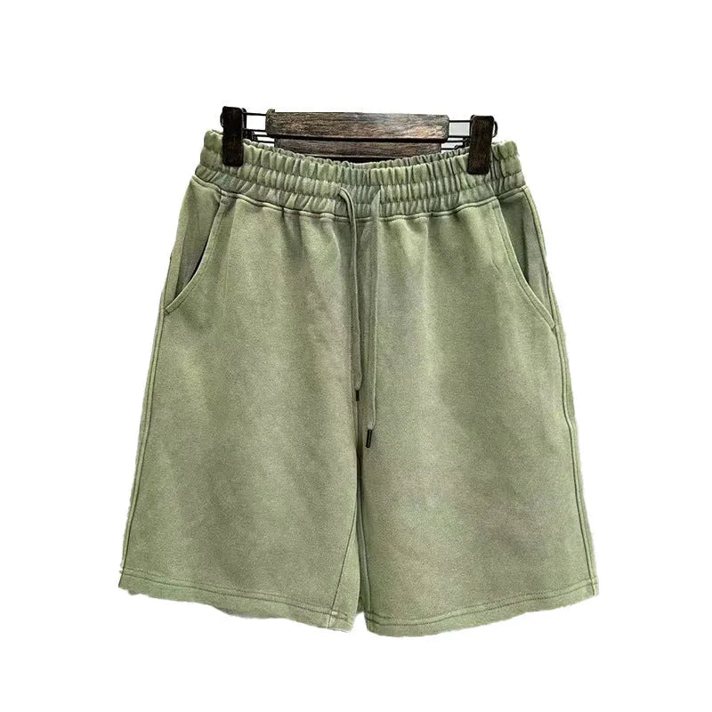 Men's distressed light blue cotton shorts with a loose straight-leg casual fit on a neutral background