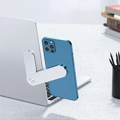 Black laptop phone holder with magnetic clip mounted on silver laptop, showing smartphone in adjustable bracket