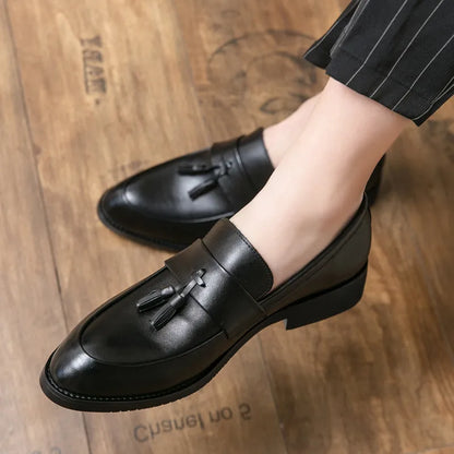 Men's black and brown business casual slip-on shoes with tassel detail and pointed toe