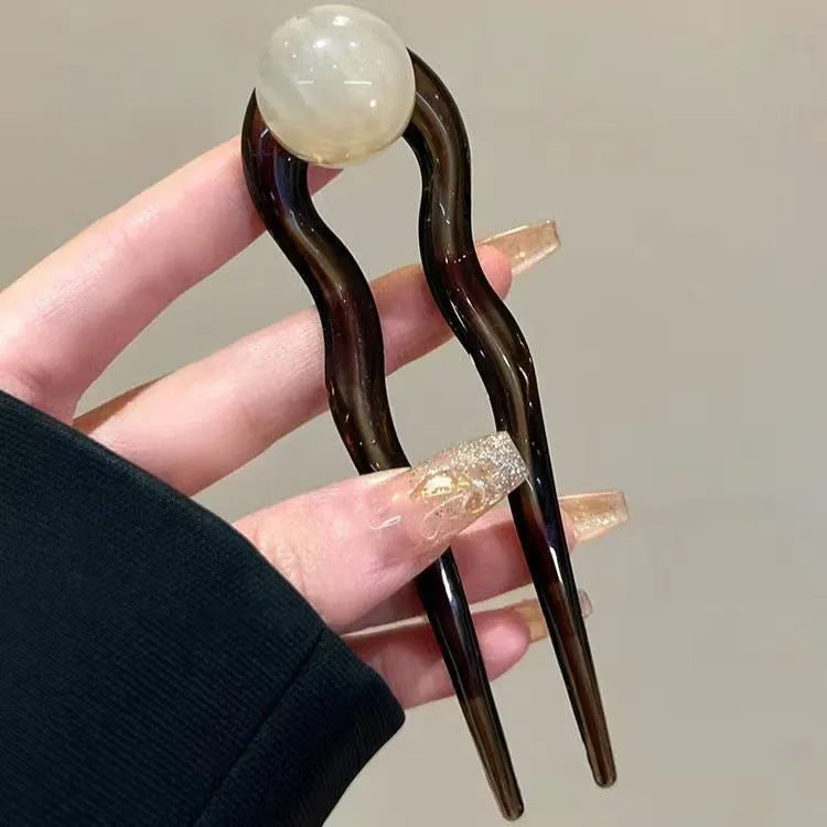 Acrylic U-shaped hair barrette with retro ball design in caramel colour