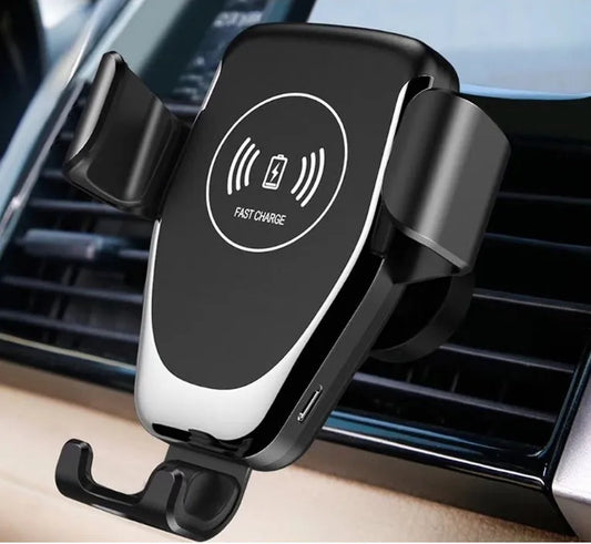 Black car phone mount with automatic clamp holding an iPhone on a car air vent, charging wirelessly.