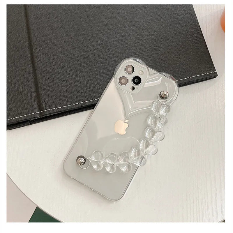 Transparent TPU iPhone case with love bracelet and heart chain design on a table.