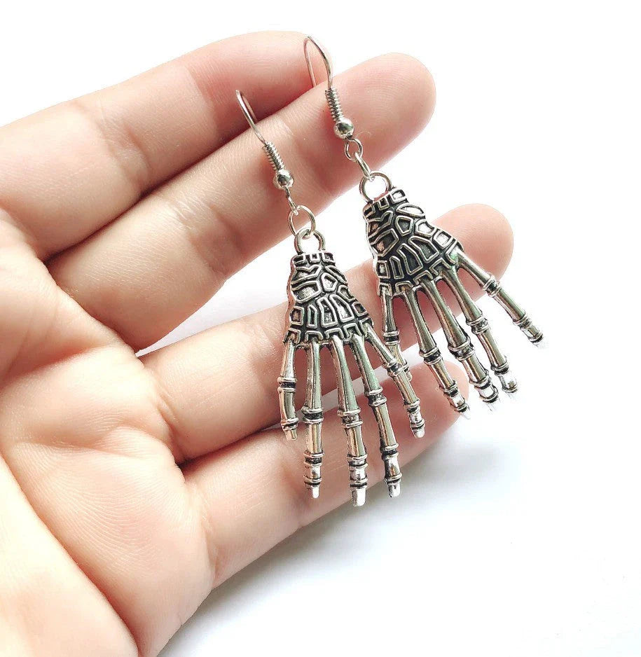 Vintage-inspired skull and skeleton earrings with intricate enamel details and a spooky-chic design