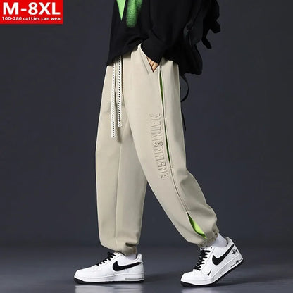 Men's ankle banded trousers in micro-elastic cotton with collage stitching details, showing loose fit and tapered leg