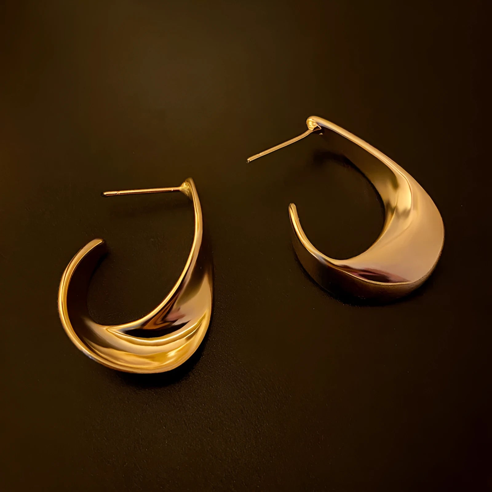 Gold twisted geometric metal earrings with circular elements and electroplated finish