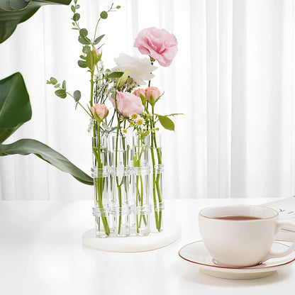 Clear glass hinged test tube vase with plants in curved arrangement