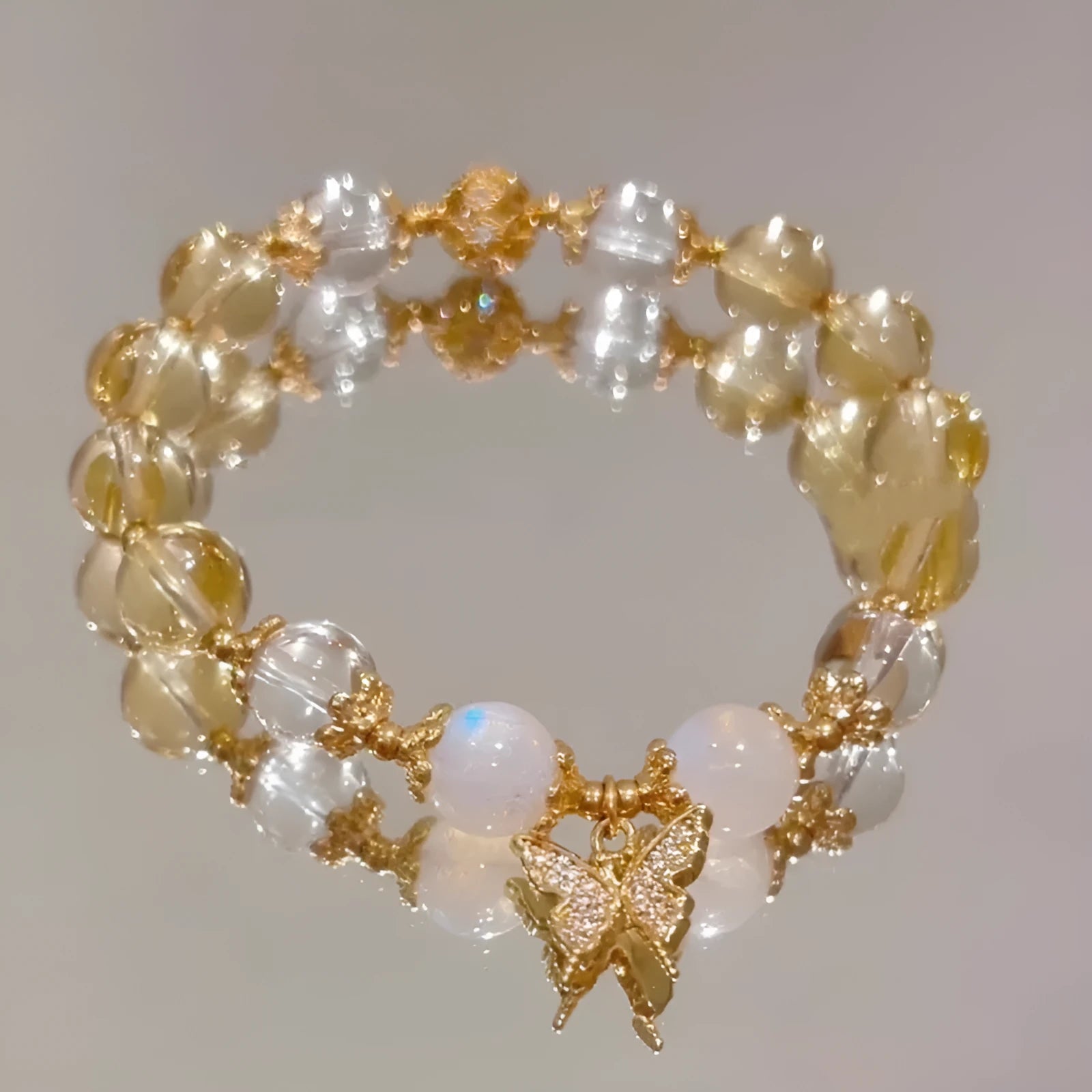 Chinese style white crystal beaded bracelet with citrine butterfly charm on adjustable string.