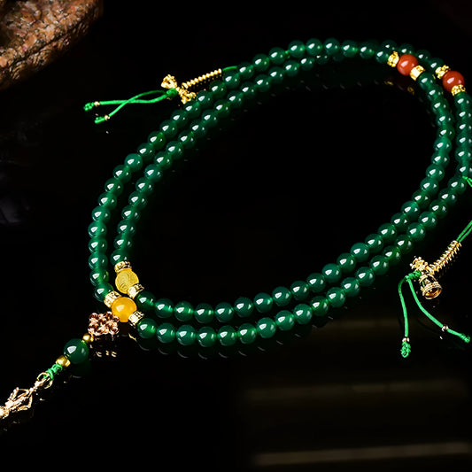 Close-up of a multi-strand green agate bracelet with natural stones on a wrist.