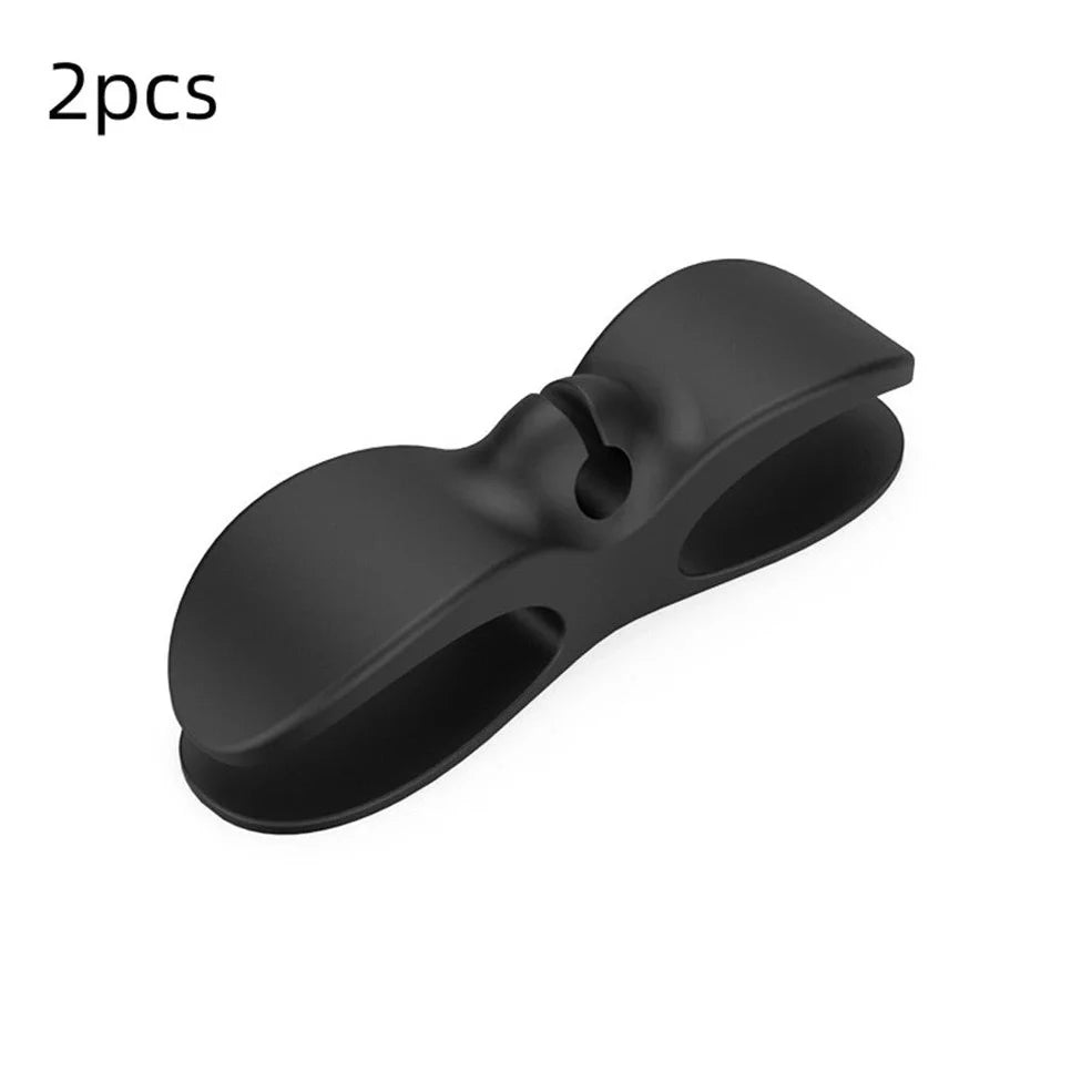 Black TPU cable organizer clips winding appliance cords on kitchen counter, 5cm size, non-marking adhesive for tidy management