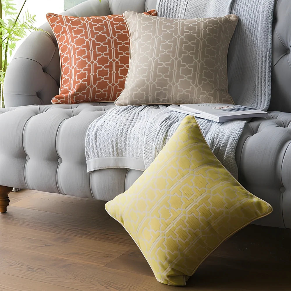 Square beige cushion cover with envelope closure on a grey sofa