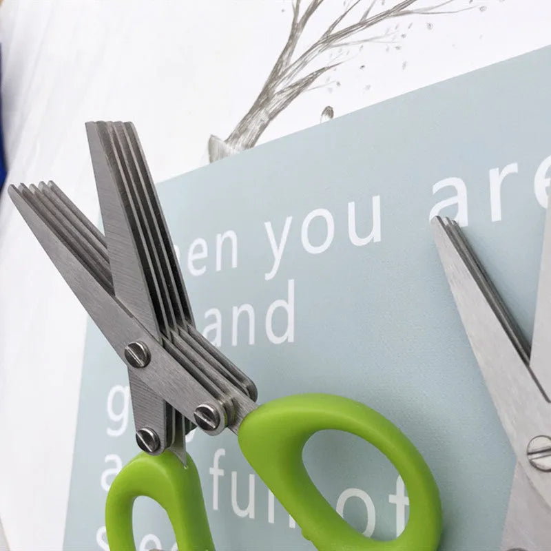 Green stainless steel multi-layer V-shaped kitchen scissors for cutting onions and herbs.