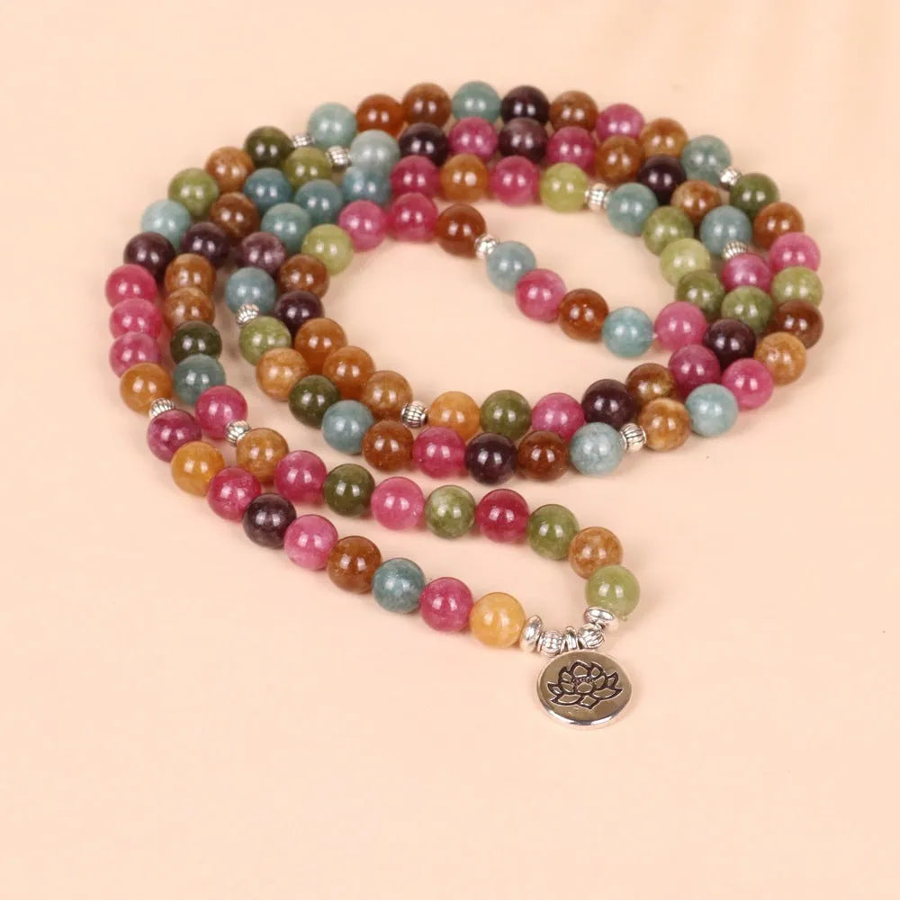 Close-up of a multi-layer beaded bracelet with 108 tourmaline beads and alloy string, showing lotus hanging detail.