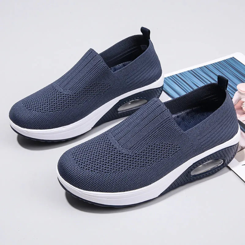 Women's beige mesh running shoes with round toe and air cushion midsole on a grey background.