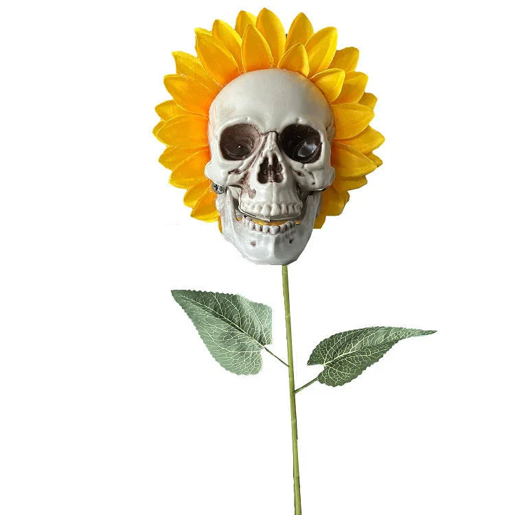 A group of skull-shaped sunflower ornaments arranged in a Halloween-themed outdoor display