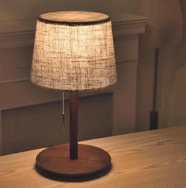 Walnut solid wood bedside lamp with fabric lampshade on wooden surface