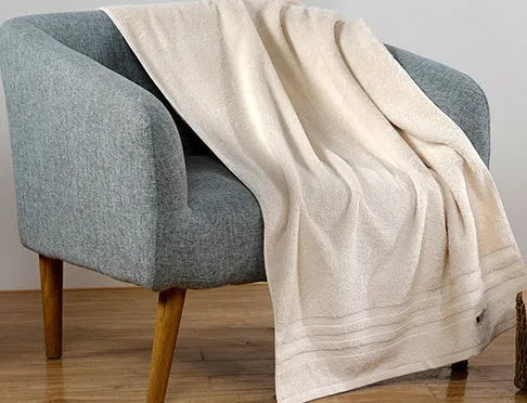 Beige and brown cotton towel set showing bath, hand, and face towel sizes.
