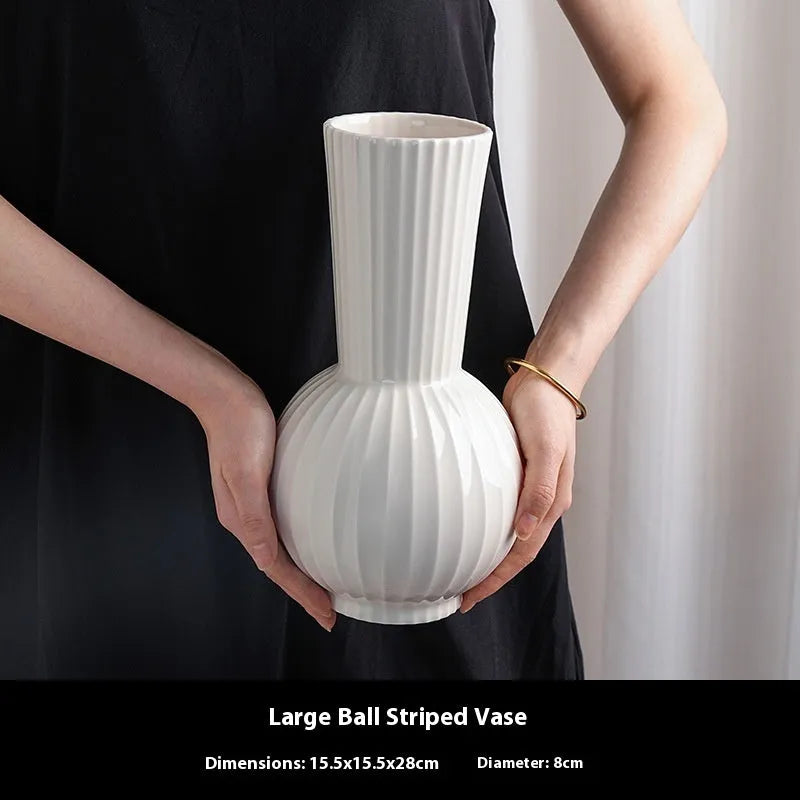 White ceramic ball-shaped vase with striped pattern, shown in small and large sizes with orchid arrangements