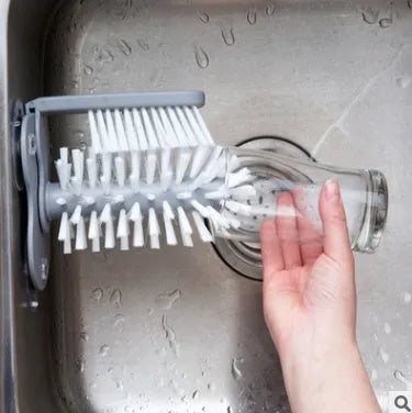 Grey rotating double-head cup brush with suction cups for wall mounting.