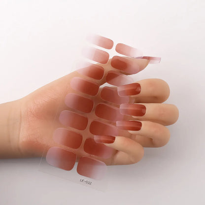 Sheet of 16 small design nail art stickers including cross, rose, tulip and marble patterns.