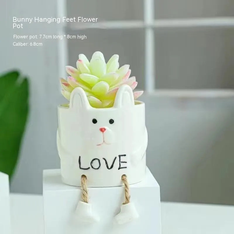 Ceramic hanging foot flowerpot for succulent plants with cartoon styling on desktop