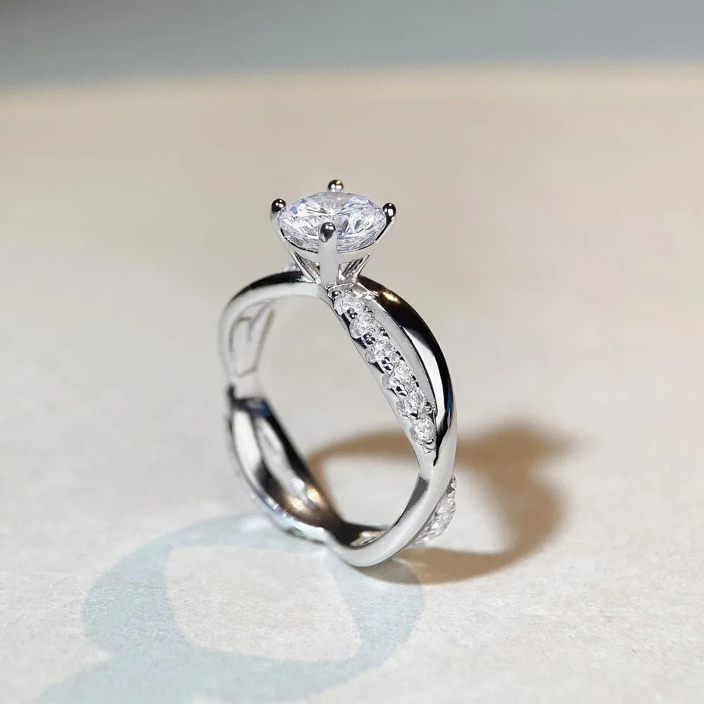 Geometric silver ring with 1 karat moissanite centre stone in four-claw setting and twisted arm band design